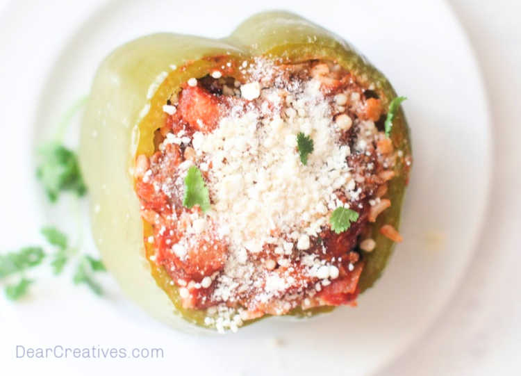 Stuffed Bell Peppers - cooked stuffed bell pepper on a plate from the top down, filled with a delicious stuffed pepper filling and Parmesan cheese on the top. Grab the recipe for stuffed peppers at © DearCreatives.com 