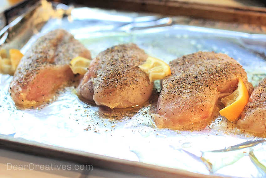 Chicken ready to be baked in the oven on a sheet pan - Baked Lemon Chicken- © DearCreatives.com