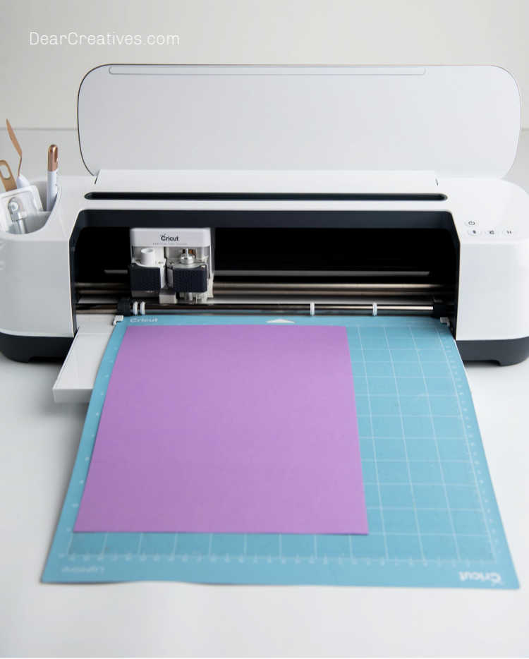 Inserting paper into the Cricut Maker to cut the template for utensil holder - Cricut Crafts, DIY and Instructions at DearCreatives.com