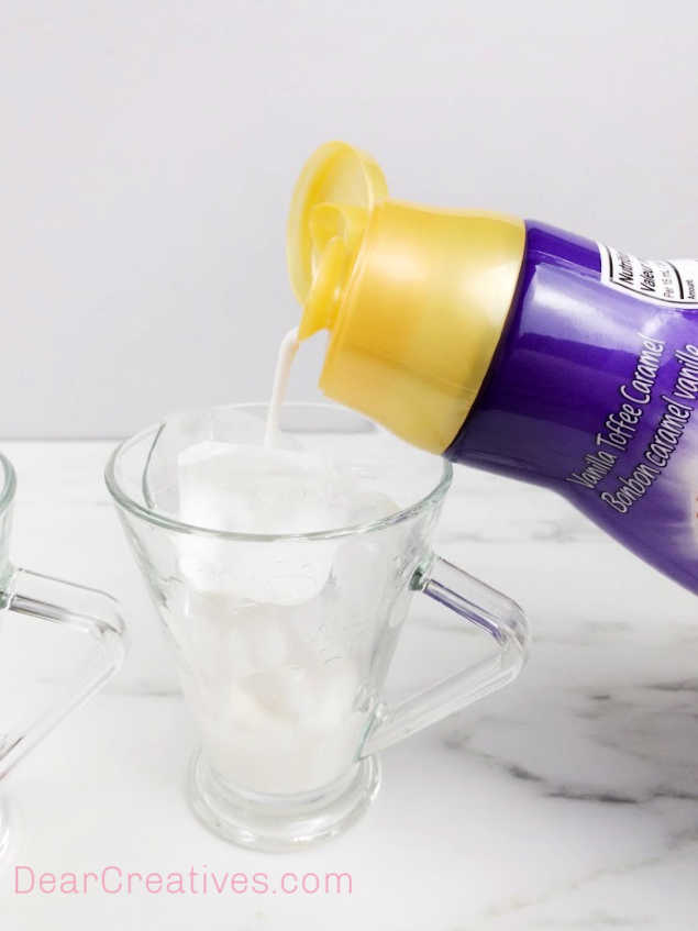 Adding the optional creamer flavoring to the milk and ice for the whipped coffee. Recipe at DearCreatives.com