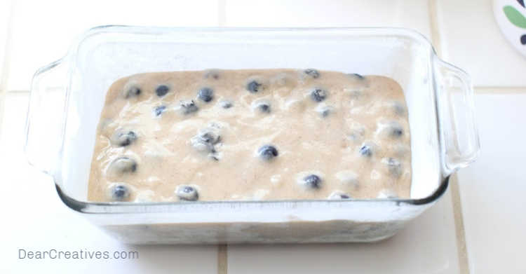 blueberry batter in a prepared bread pan for baking blueberry bread - © DearCreatives.com