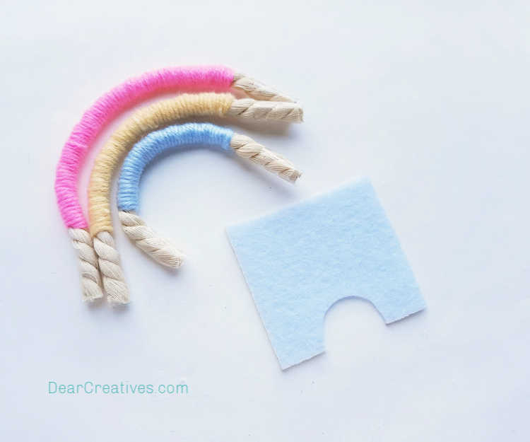 step (7) For Backing - Take a piece of the felt and cut an arch shape out of the felt from its bottom side. Macrame Rainbow instructions at DearCreatives.com.