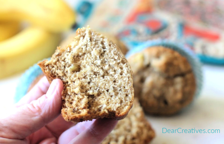 homemade banana muffins ready to be eaten - holding a cooled sliced banana muffin to eat - DearCreatives.com