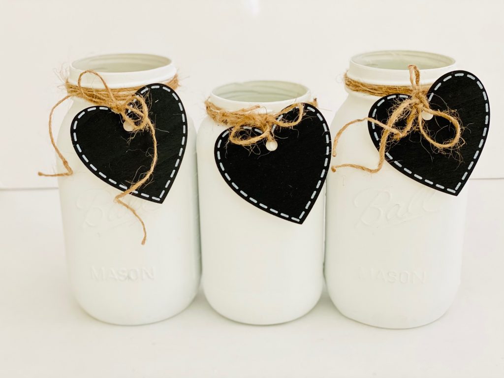 mason jars with heart tags tied on with twine - See how to make and style this craft project for your decor, farmhouse decor or for Valentine's Day mason jars...DearCreatives.com