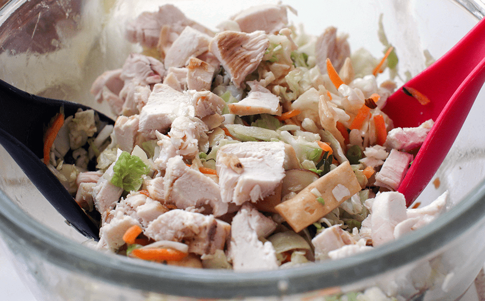 Chopped cooked rotisserie chicken being added to the salad© DearCreatives.com