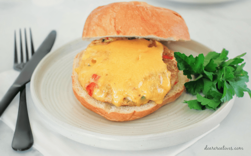 Ground chicken hamburgers baked - close up of a chicken hamburger with cheese on a bun. Get the recipe at DearCreatives.com