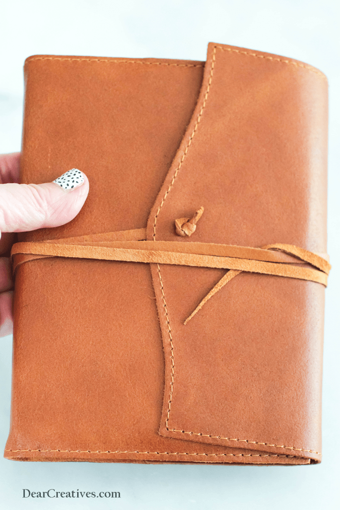 high quality leather with a journal with a leather tie and lined pages for writing in. holding a leather journal © DearCreatives.com