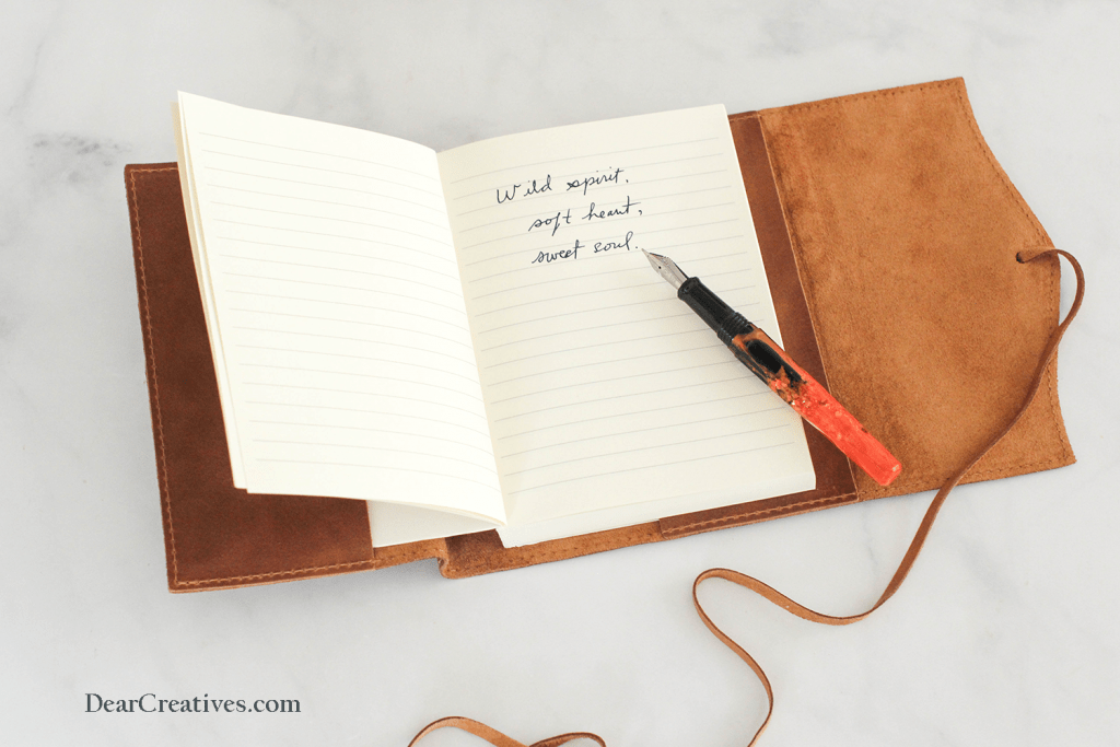 writing a quote in a journal - wild spirit, soft heart, sweet soul - journaling tips and quotes to write in journals © DearCreatives.com