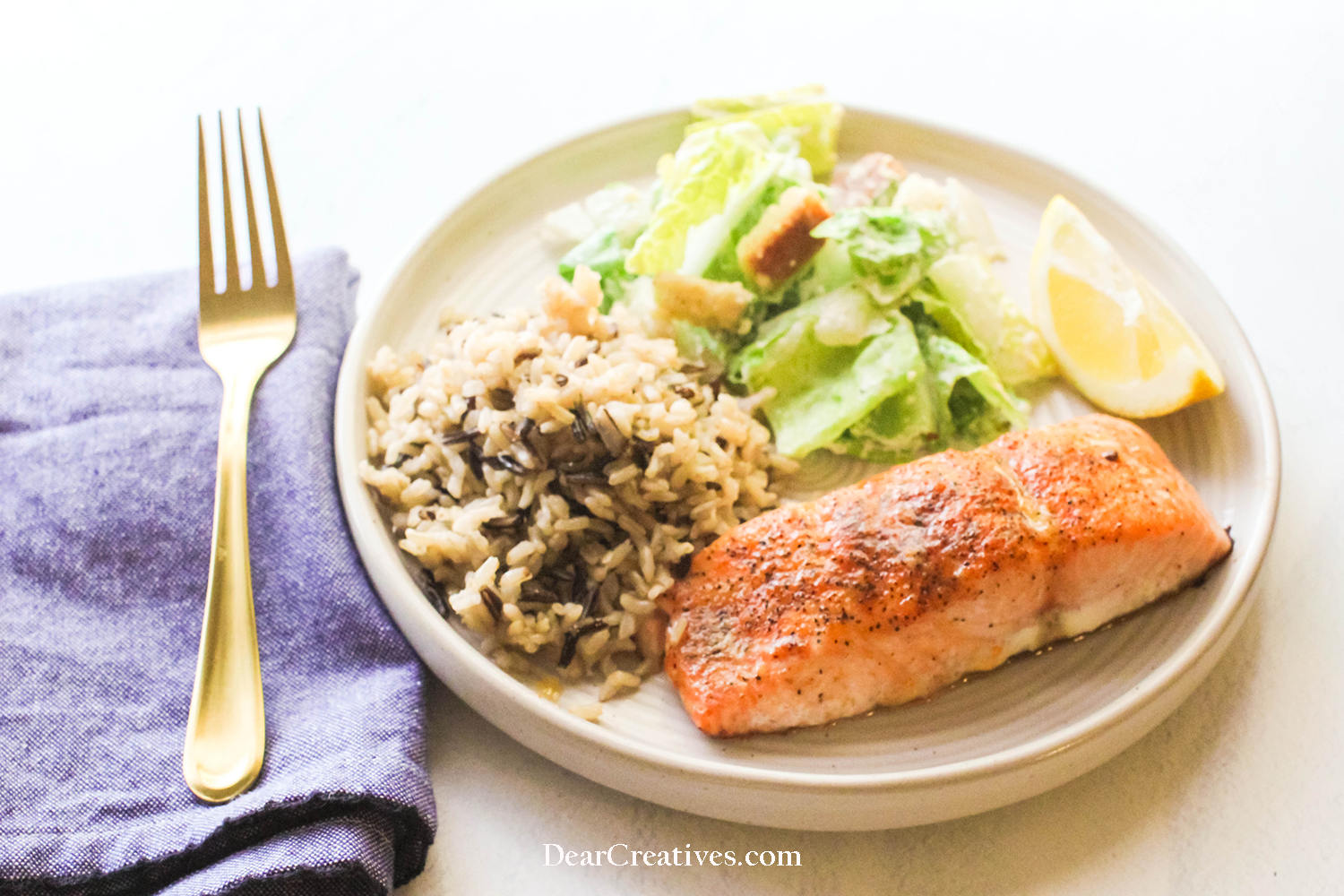 Baked Salmon on a plate with Ceasar Salad and rice - salmon dinner recipe at © DearCreatives.com