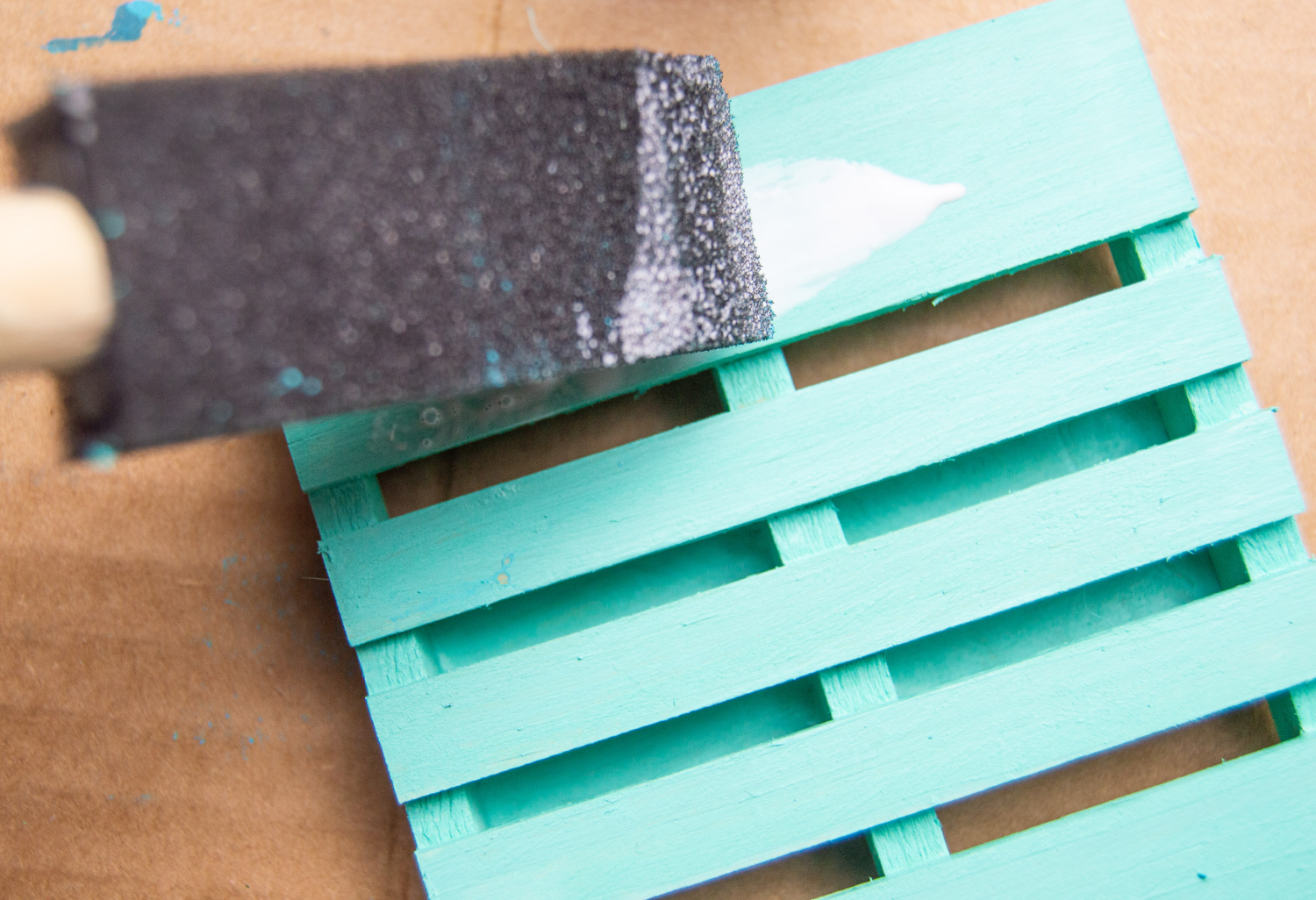 Coastal Pallet Coaster being sealed with Mod Podge - See the DIY Coasters at DearCreatives.com.