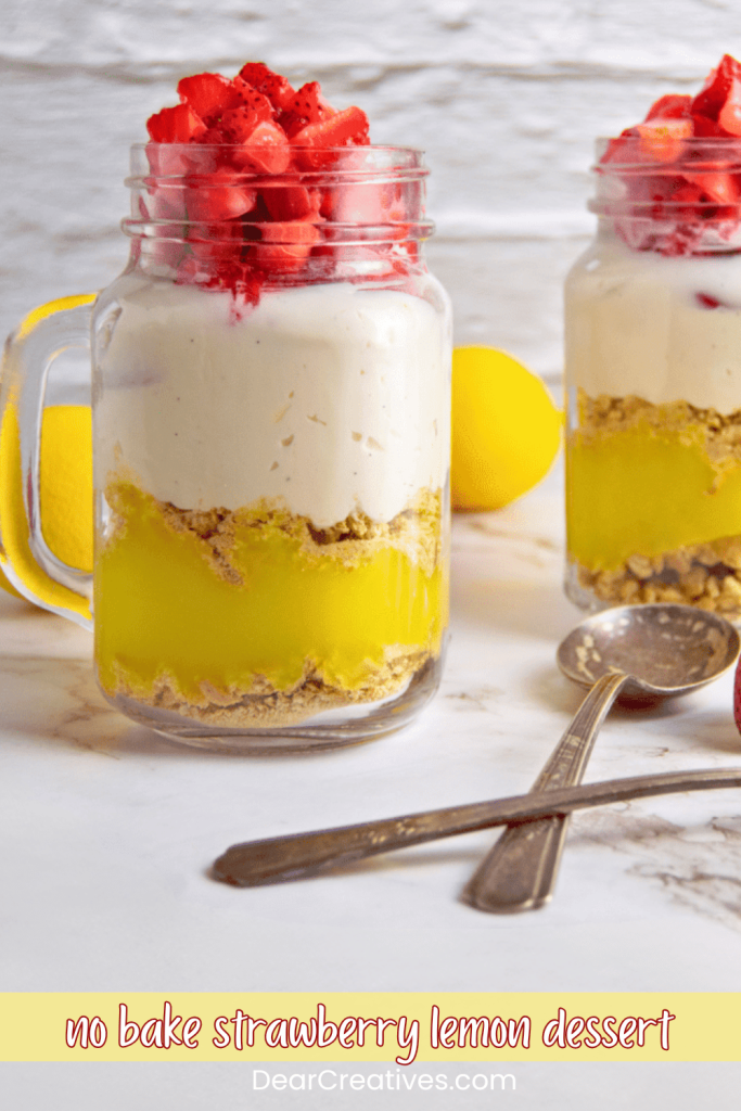 no bake strawberry lemon dessert - A lemon strawberry dessert in two mason jars on a counter with two spoons and lemons in the background. 