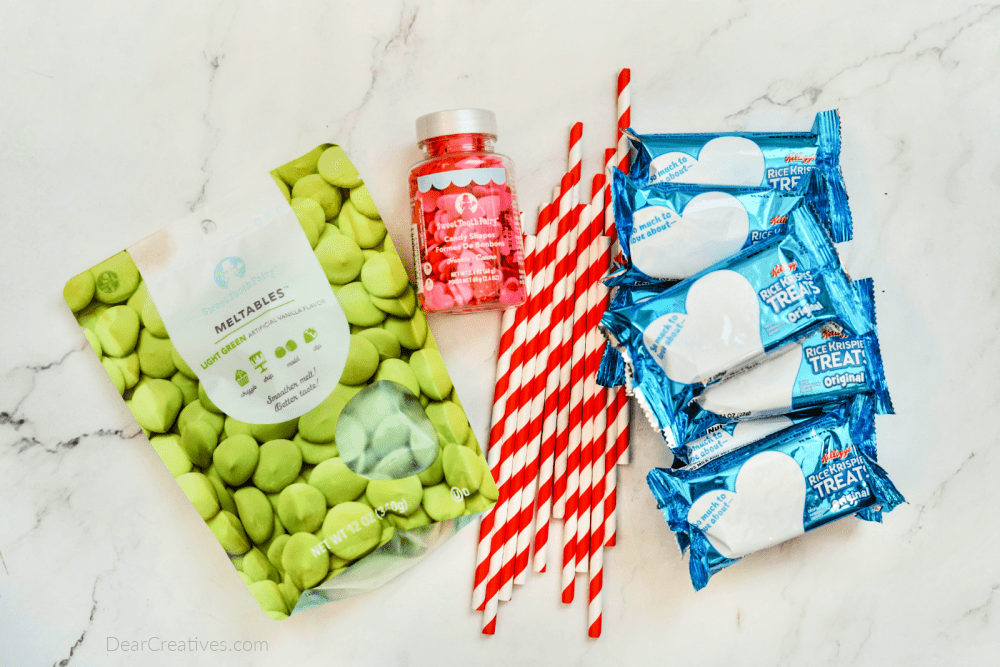 Grinch Krispie Treats Ingredients - green chocolate melts, candy hearts, Rice Krispie Treats, and striped straws. Easy no bake sweet treat for holiday celebrations. DearCreatives.com .