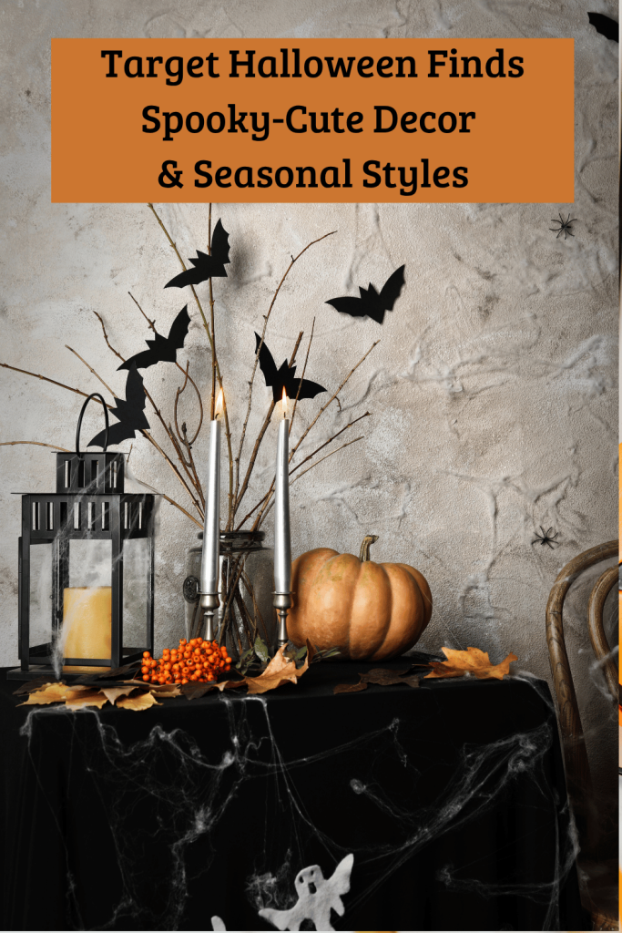 Halloween table decorated with a pumpkin, candles, lanterns, bats, cobwebs, and autumn leaves