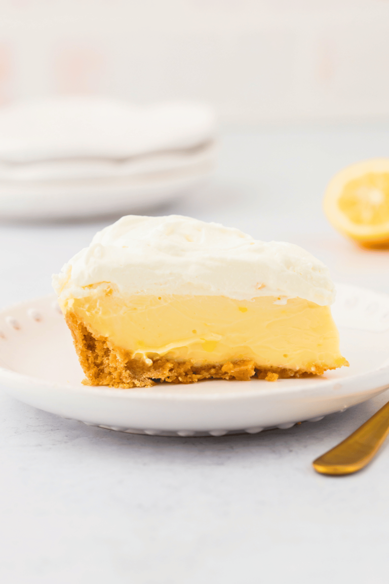 Slice of lemon pie recipe inspired by Magnolia with graham cracker crust and creamy lemon filling