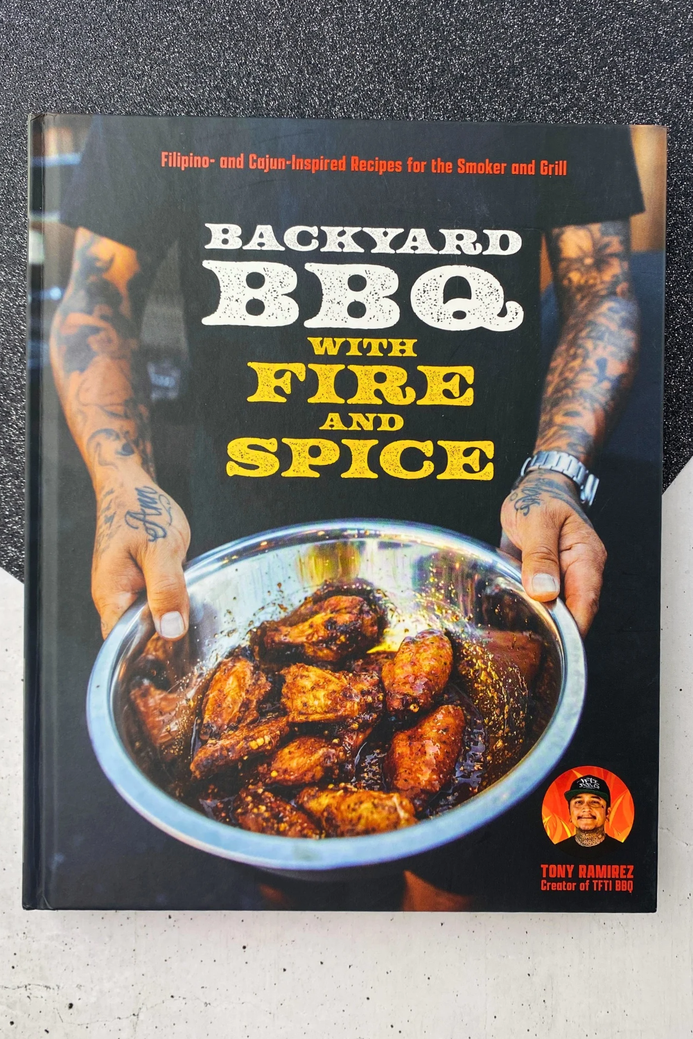 Backyard BBQ with Fire and Spice cookbook showing a delicious BBQ chicken in a pan or bowl