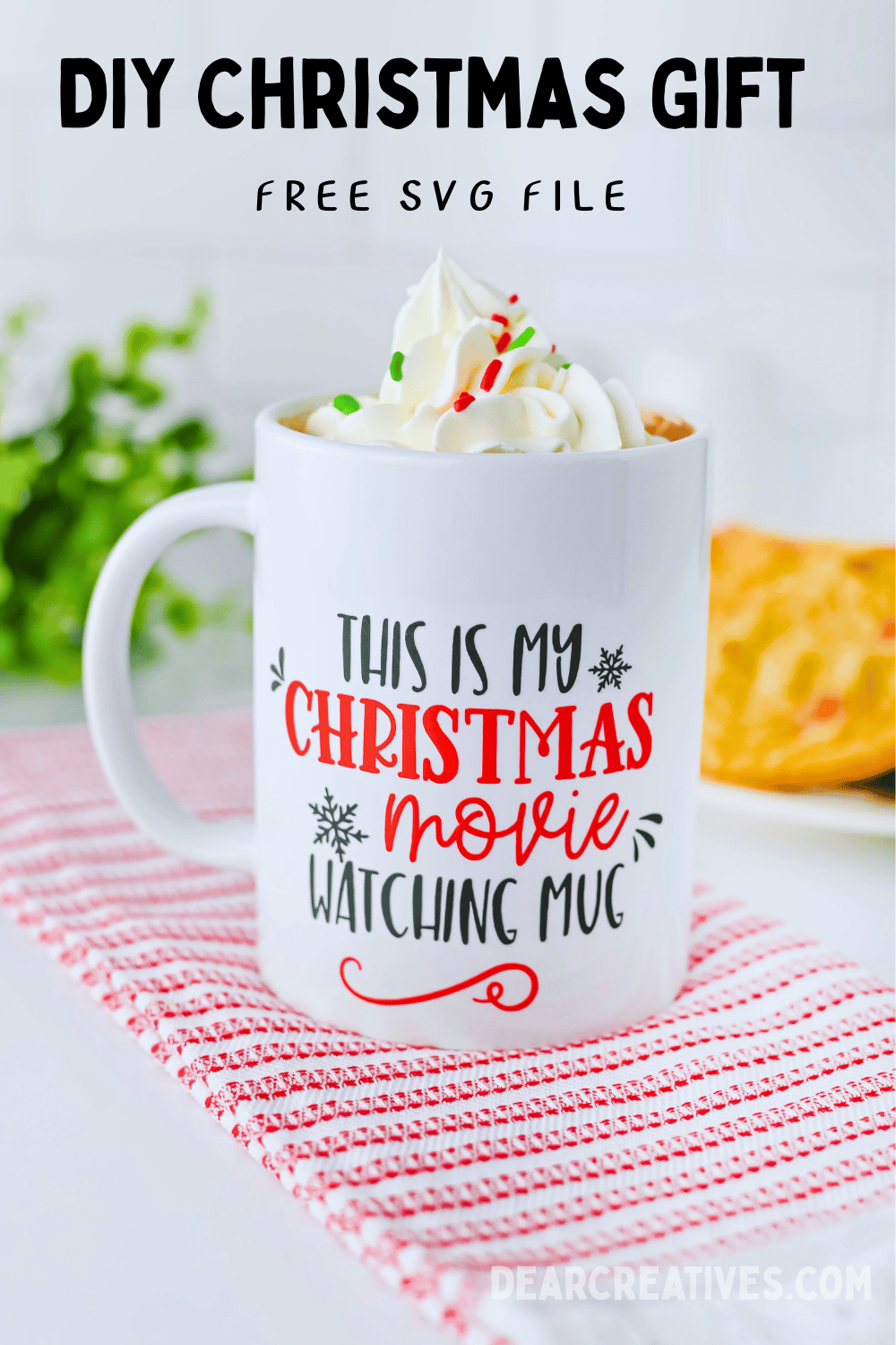 DIY Christmas Gift DIY Christmas Mug [no heat press] SVG file This is my Christmas Movie Watching Mug. Get the file and tutorial at DearCreatives.com image of a white mug with the text this is my Christmas movie watching mug. The mug is filled with a beverage and whip cream and holiday sprinkles on top. The mug is sitting on a red and white kitchen towel with cookies in the background and a plant or greenery.