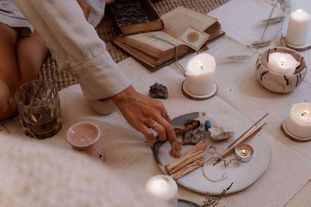 A peaceful ritual scene with books, candles, crystals, and incense sticks on a wooden table. Witchy Halloween Season