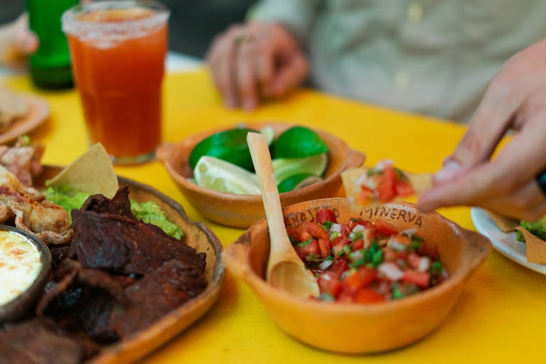 Close-up of a delicious meal featuring homemade salsa, beef or steak, and lime on a vibrant table setting.