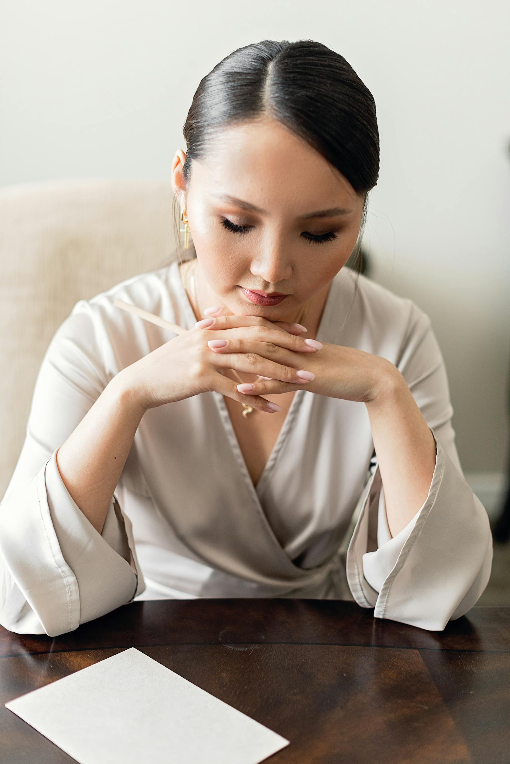 Woman sitting at a table for goal setting and vision board creation for an intentional lifestyle.