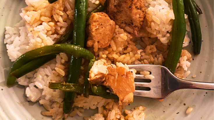 chicken and green beans served over rice on a plate