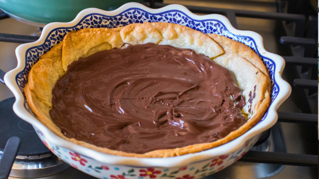 photo of melted chocolate being spread on the cooled pastry crust