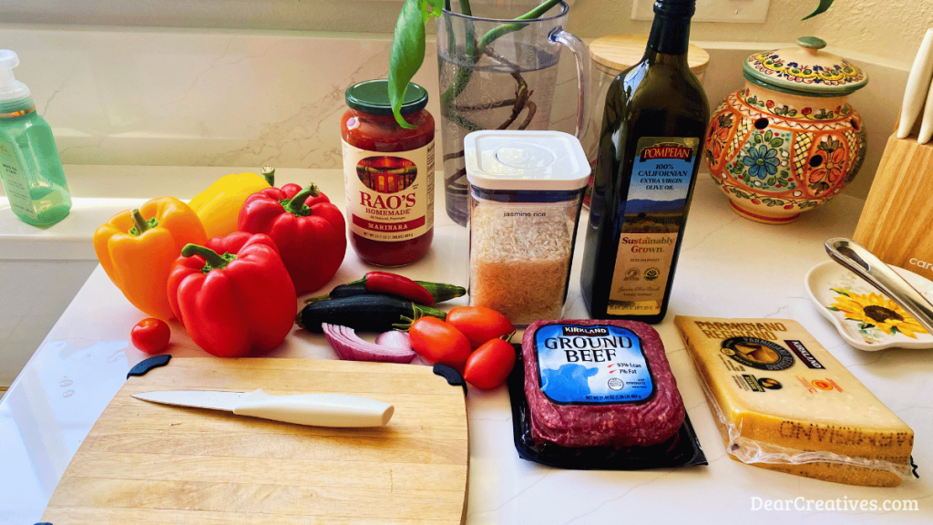 Ingredients for Slow cooker stuffed bell peppers with ground beef, rice, zucchini, tomatoes, and Parmesan cheese, cooked in marinara sauce 