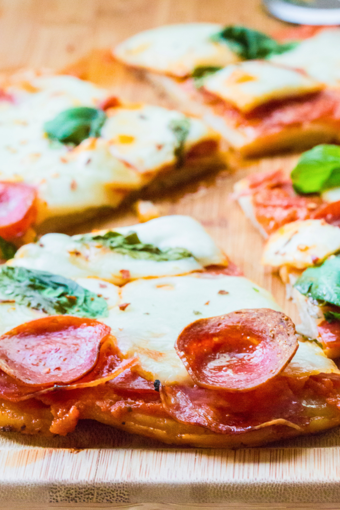 Easy pepperoni and salami pizza cut into four large slices and ready to serve.